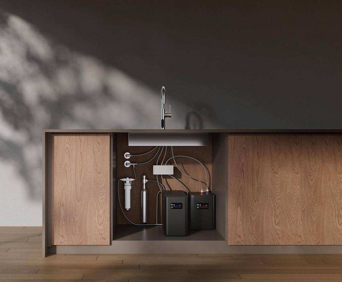 Cutaway of a kitchen cabinet showing both under-sink machines, the filter and the pipework in place